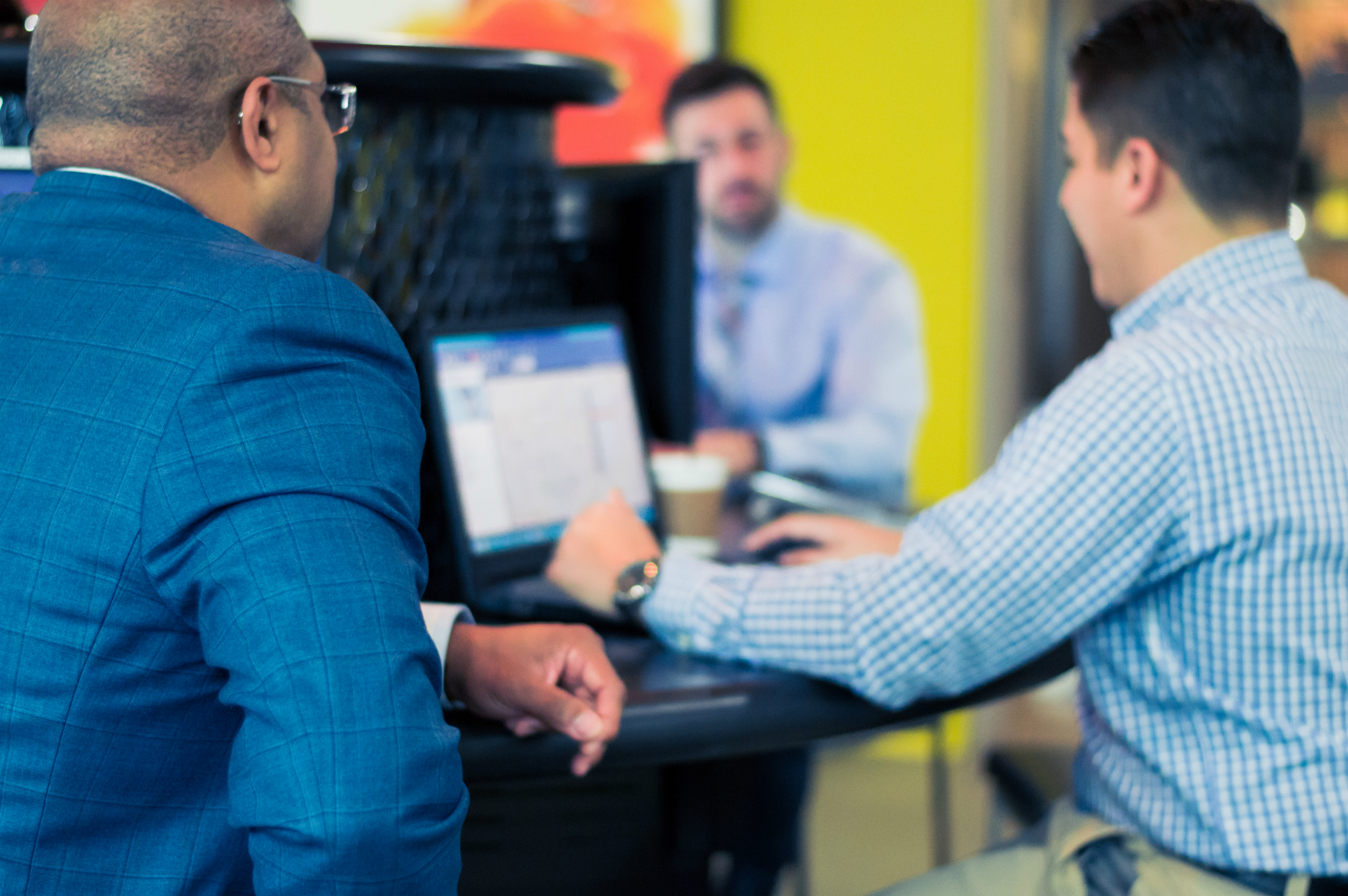 Photo of three people sitting around a laptop hunting for luxury apartments in Little Rock, Arkanas.